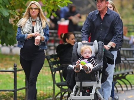 kate and michael in the park, michael holding baby pram with his son in it 